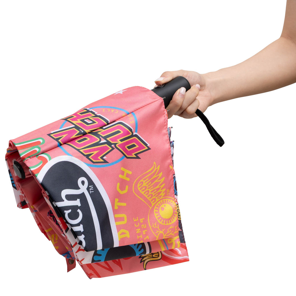 Compact automatic umbrella folded, pink collage print fabric sleeve with black strap handle