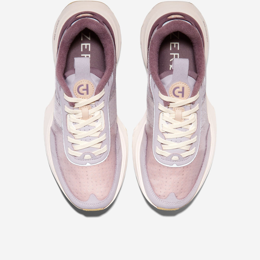 Women's sneakers with white laces and mauve collar; front view showing tongue.