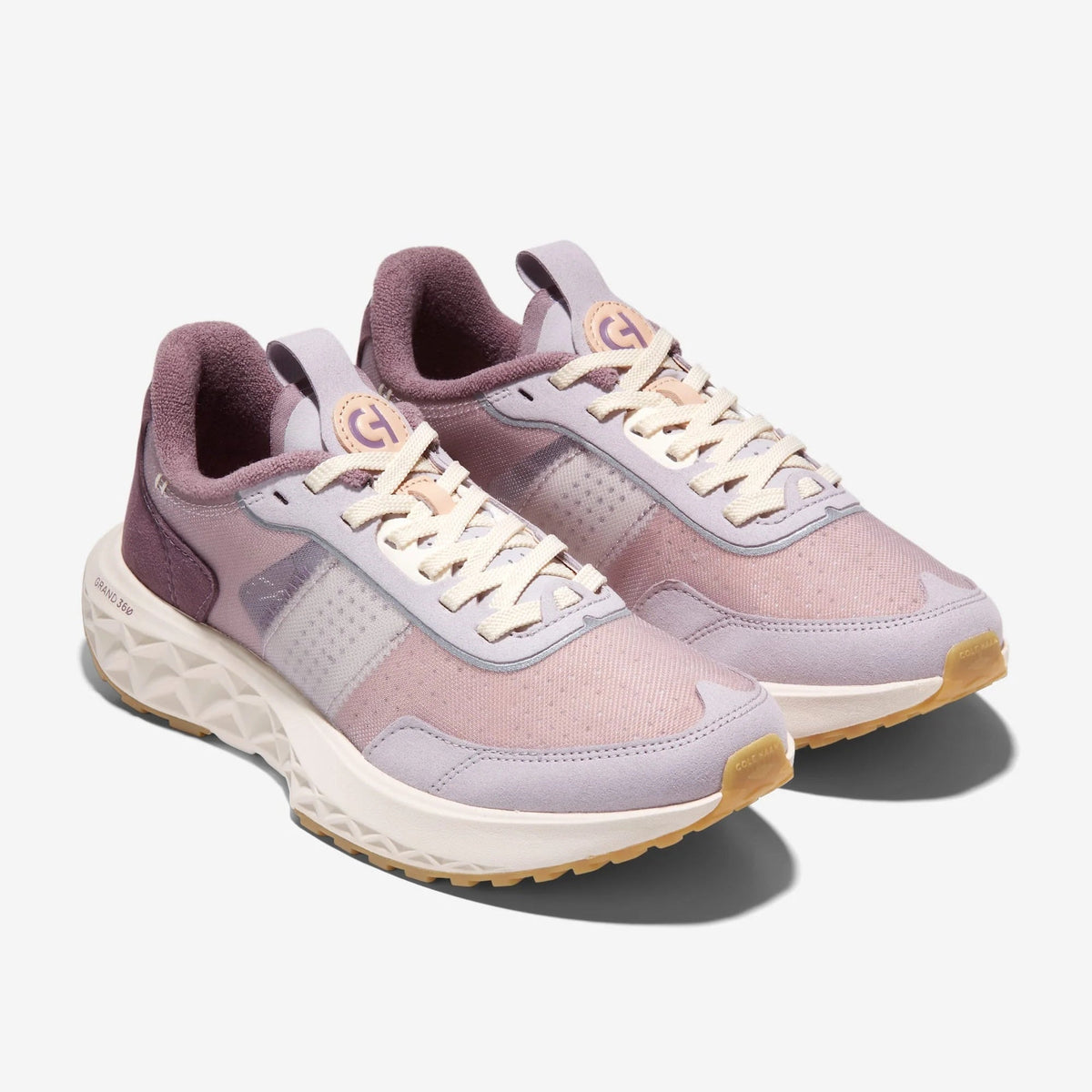 Women's lace-up sneakers in mauve and lavender with perforated panels and cream sole.