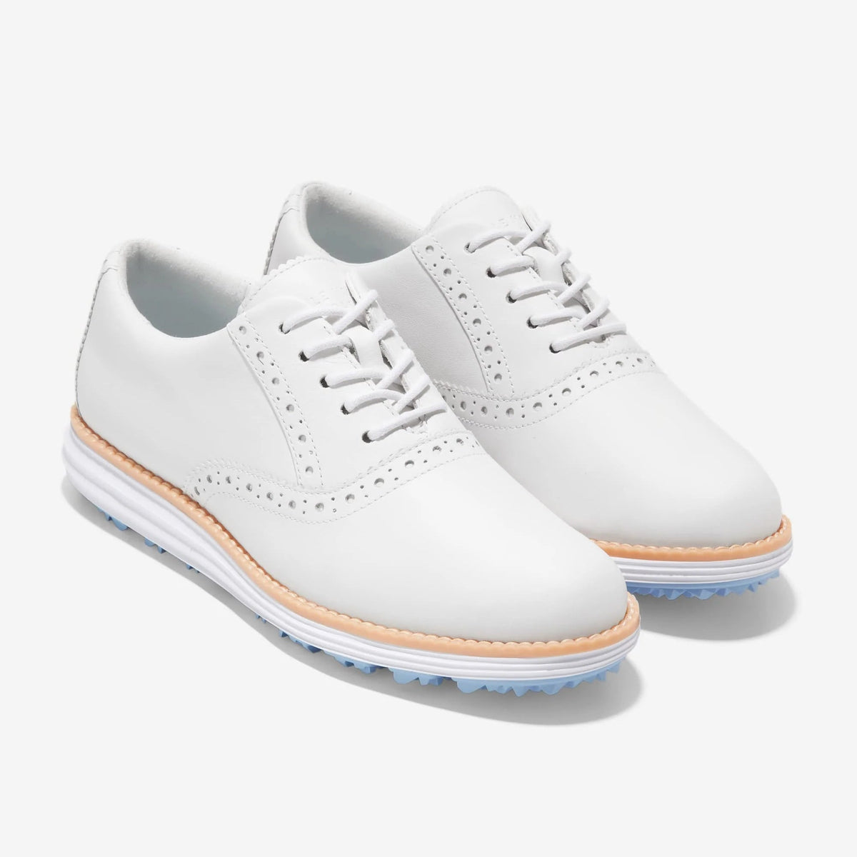 White leather oxford golf shoes with lace-up detail, tan welt, and blue rubber sole