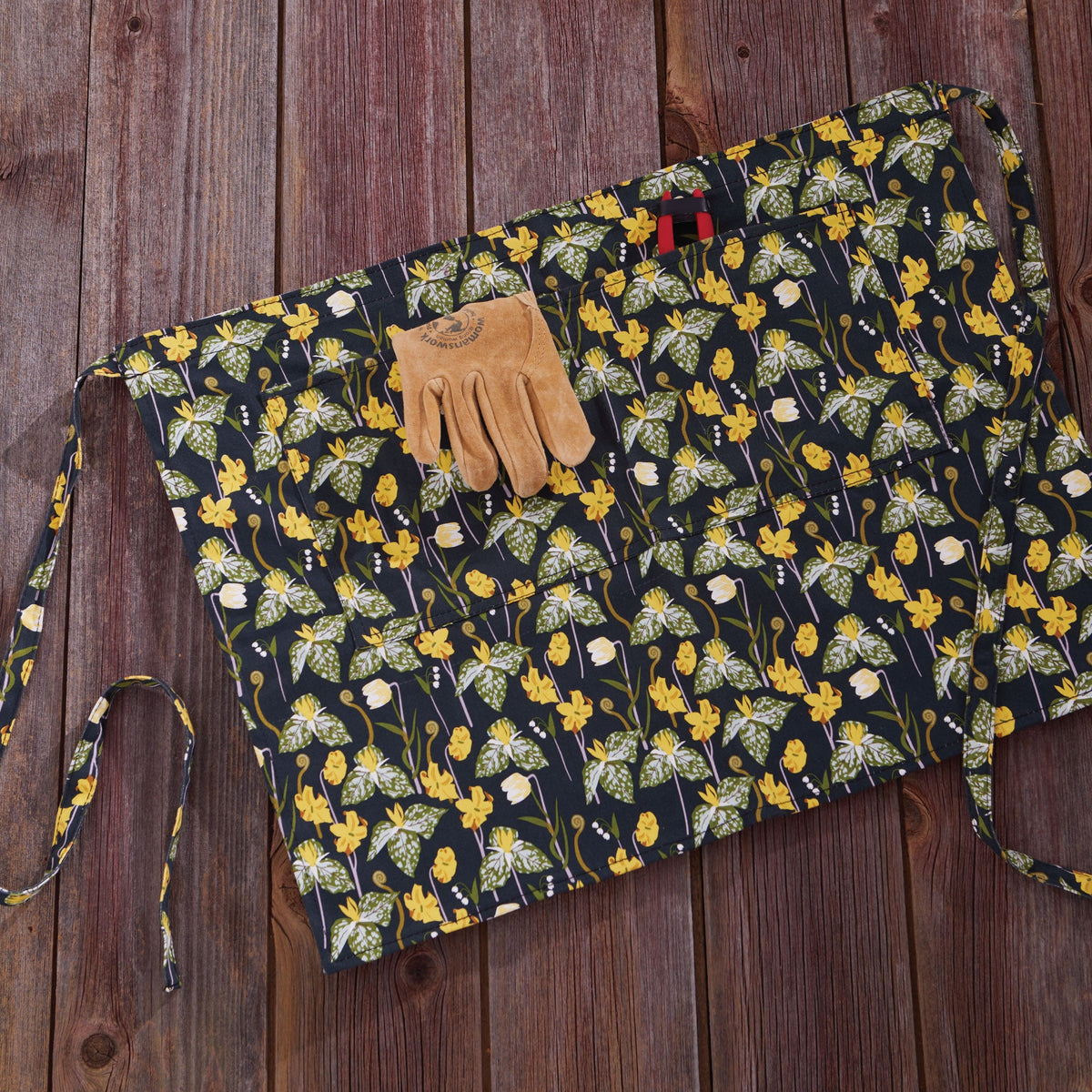 Floral half apron with long ties and front pocket, dark fabric with yellow flower print