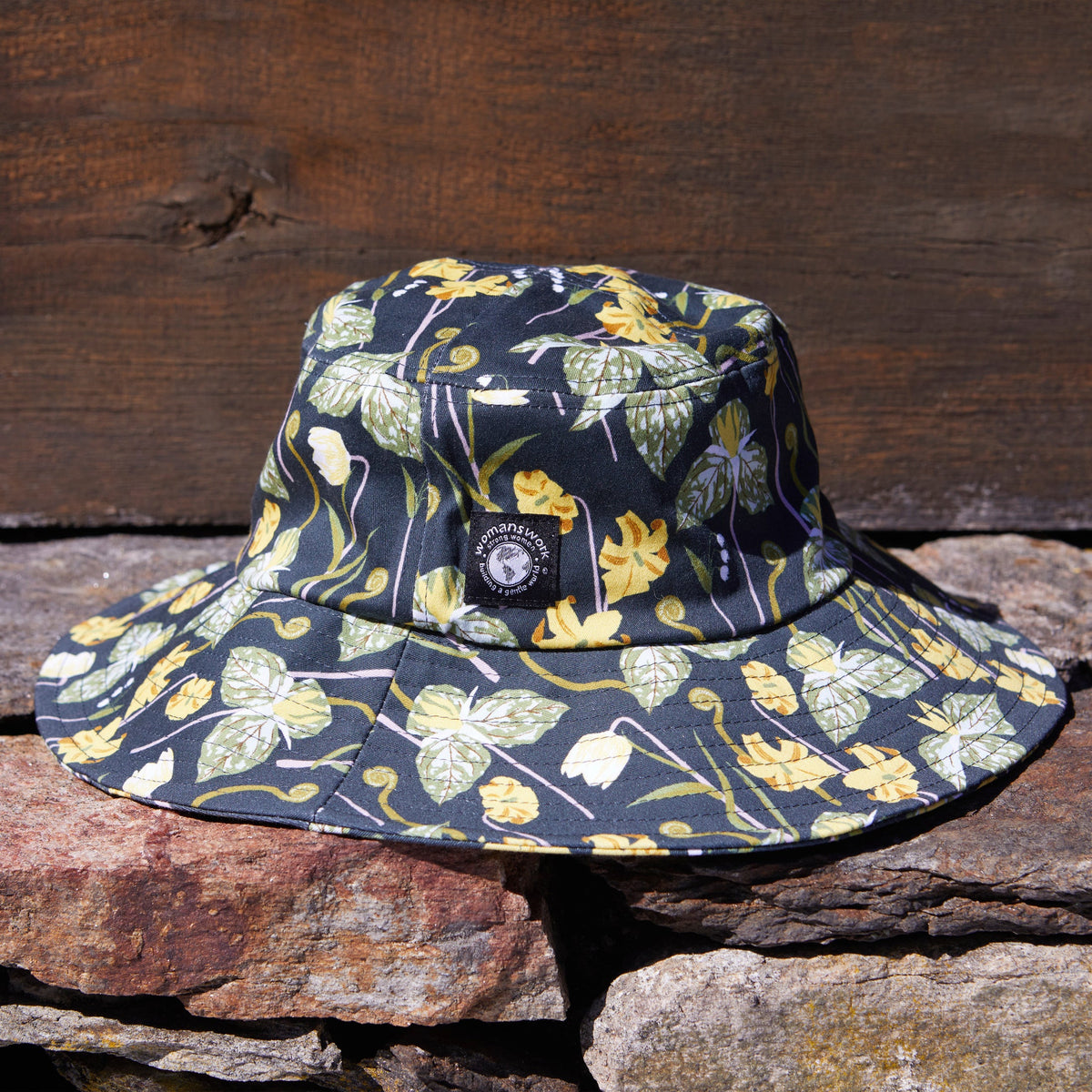 Cotton bucket sun hat with floral print, wide brim and front logo patch.