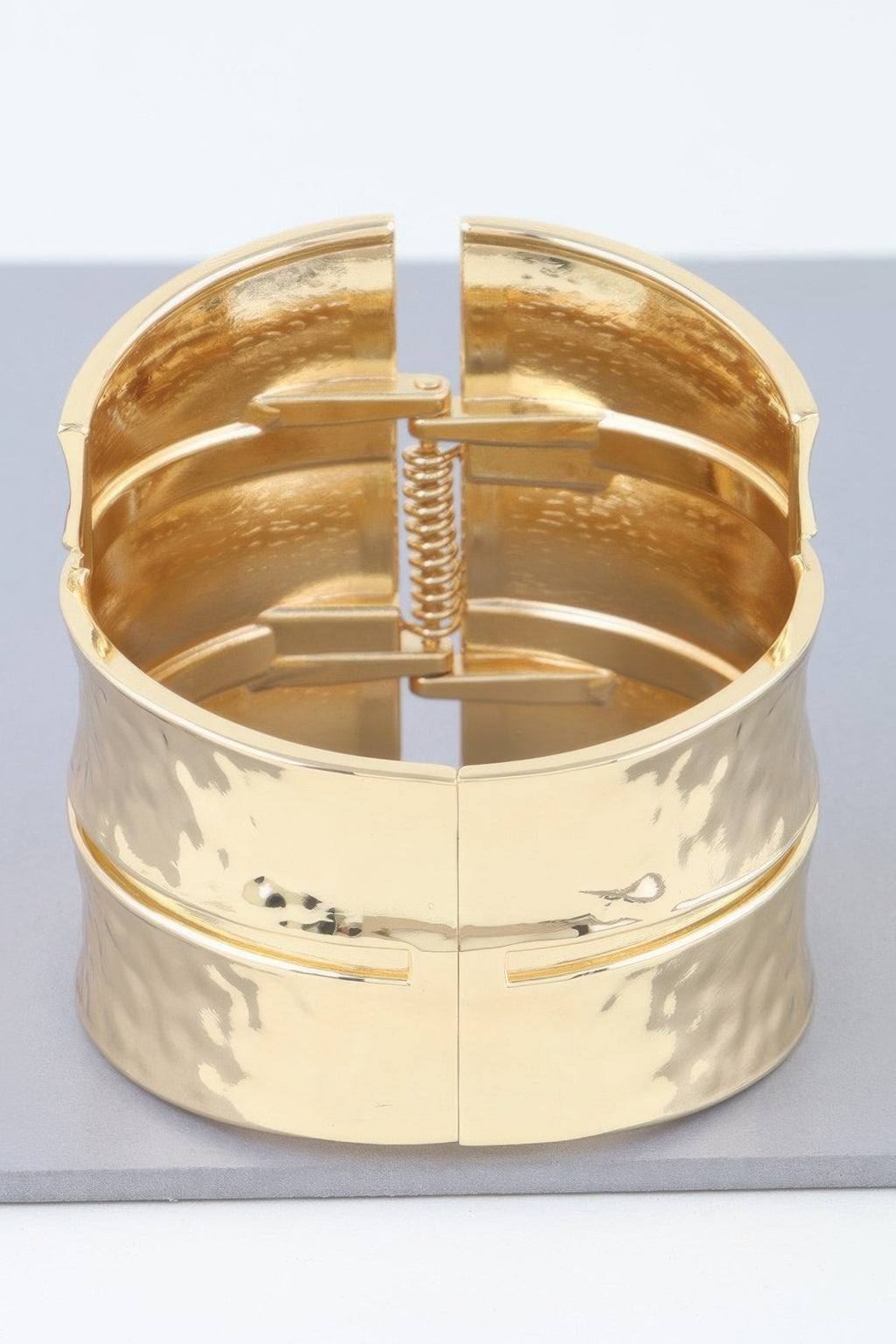 Women's gold-tone cuff bracelet with hinged clasp and engraved animal motif