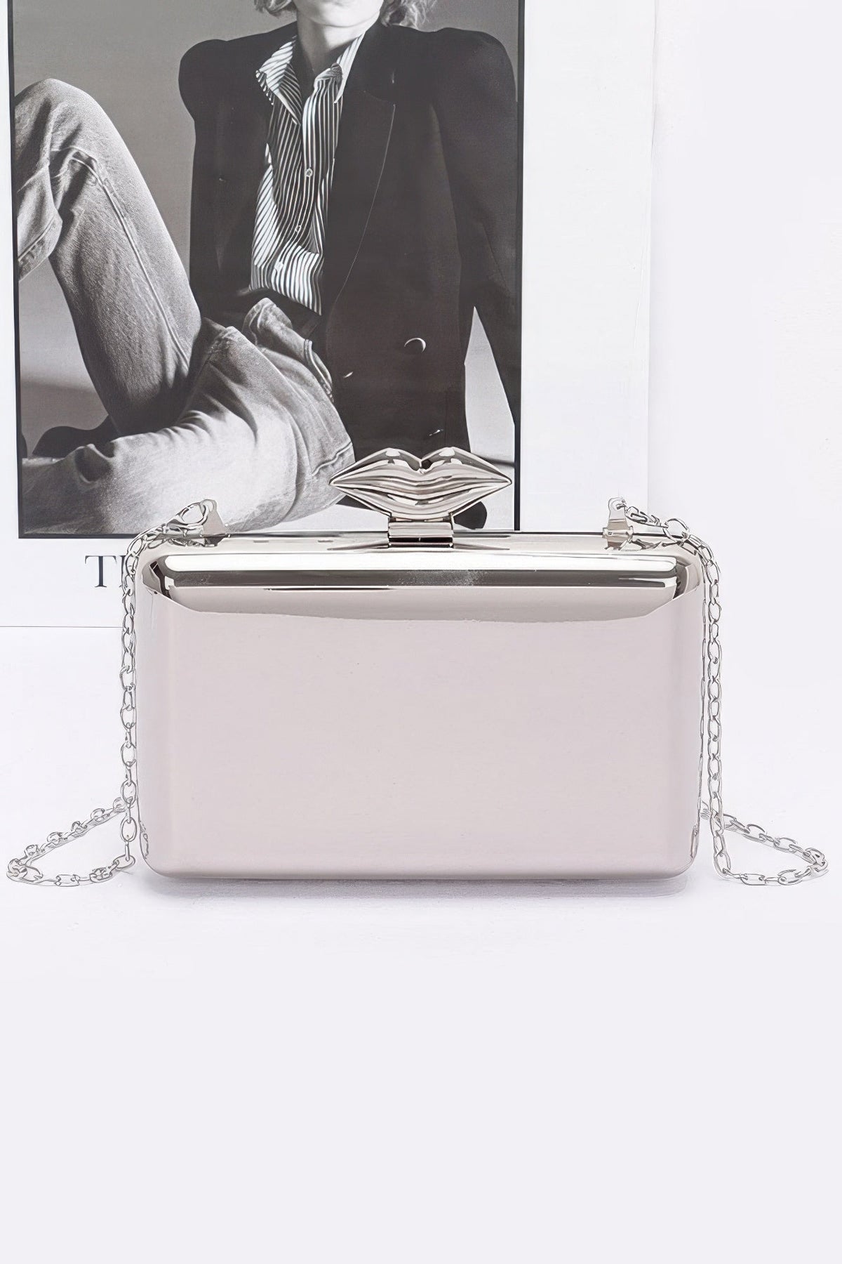 Silver-tone women's clutch with chain, hinged top and decorative emblem clasp