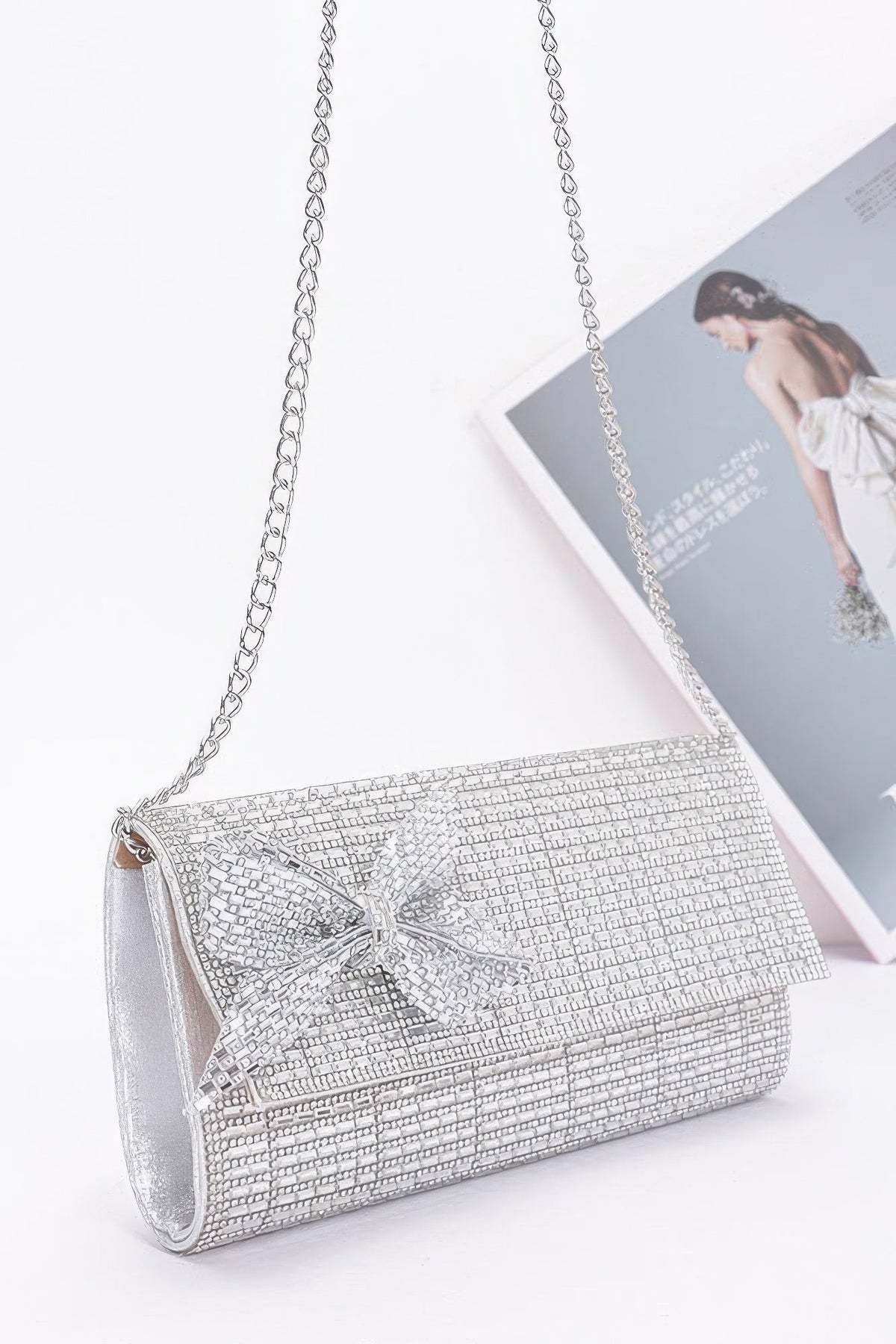 Silver beaded clutch bag with bow front and chain shoulder strap