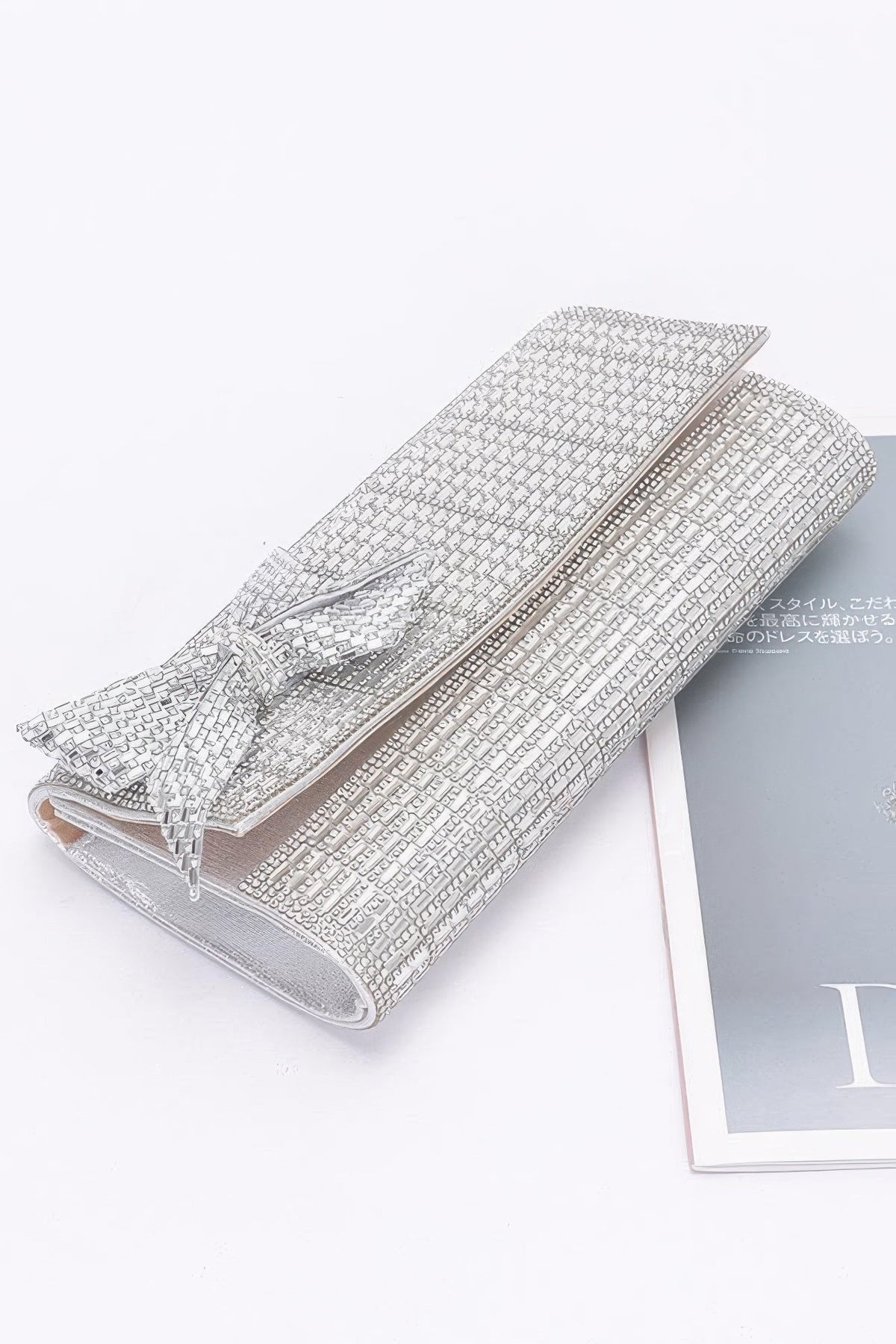 Silver beaded clutch with bow and fold-over top; chain strap
