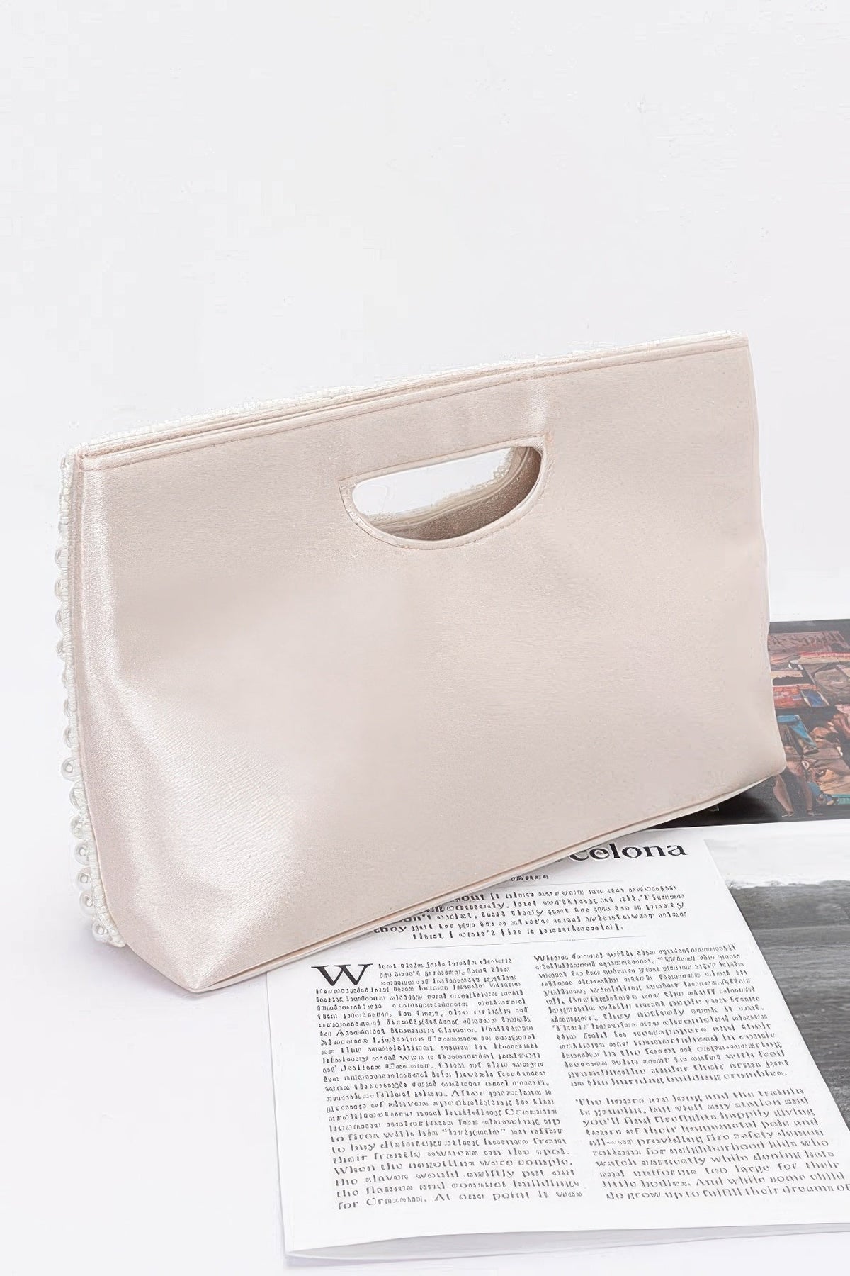 Cream satin clutch bag with cutout handle and beaded trim