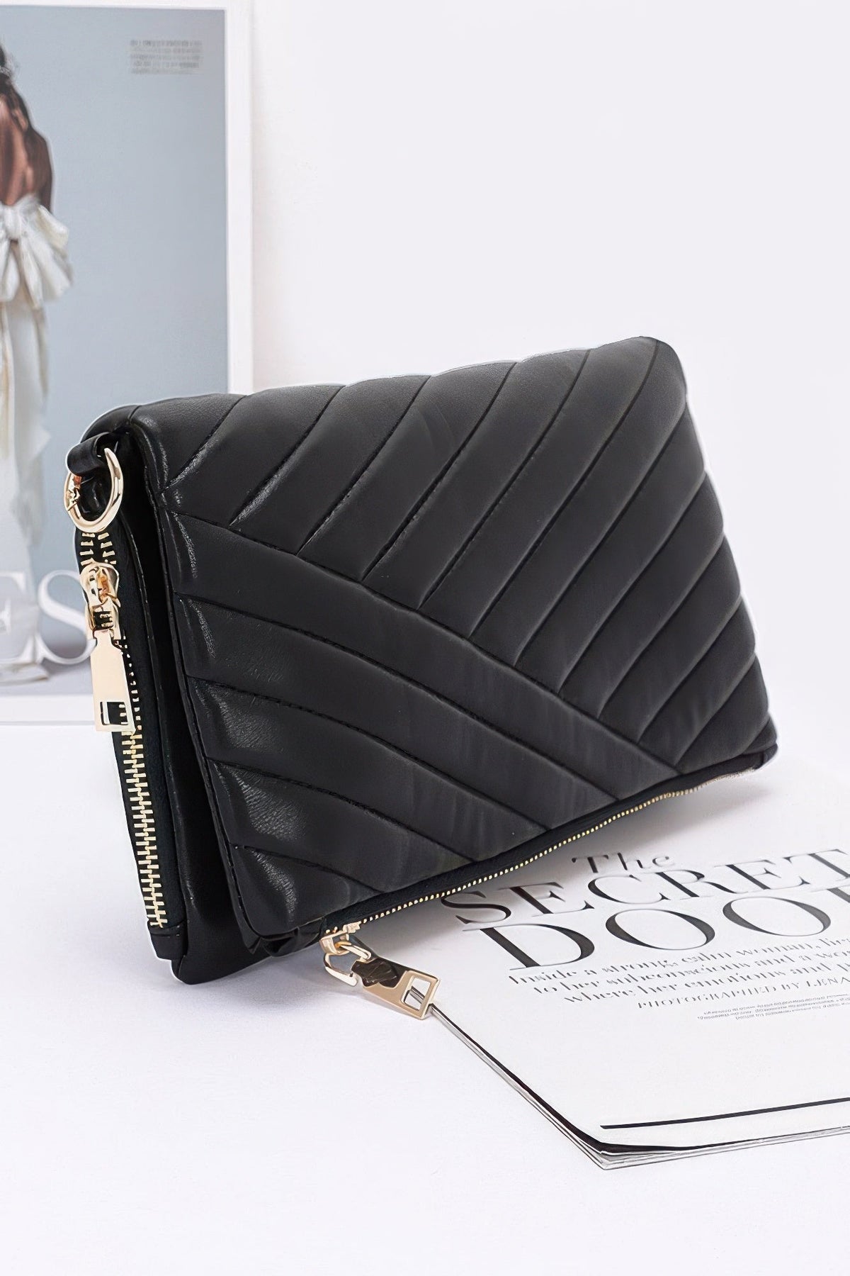 Black quilted leather-look clutch with chain strap, front zip and gold-tone hardware