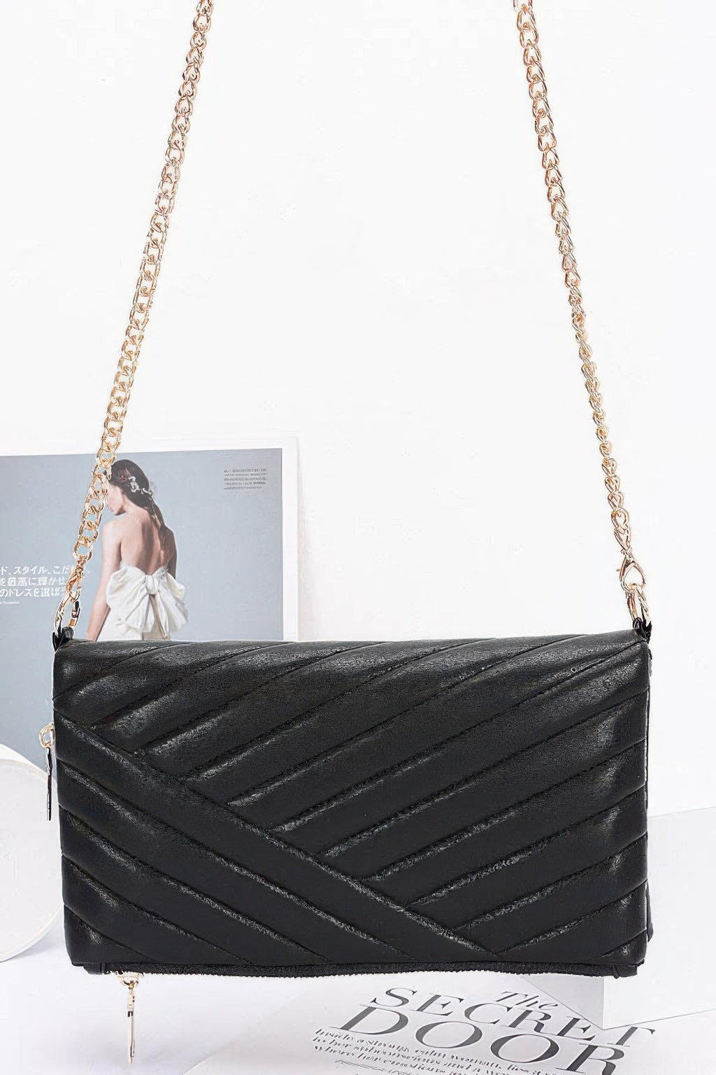 Black quilted shoulder clutch with long chain strap and gold-tone front zipper hardware
