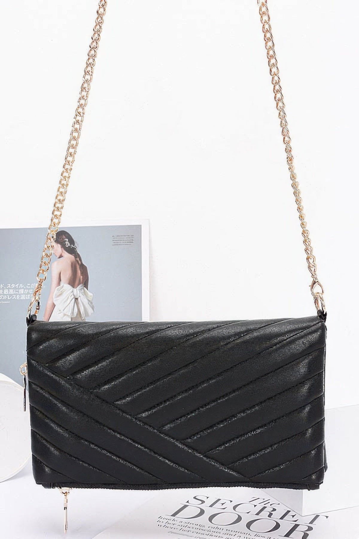 Black quilted shoulder clutch with long chain strap and gold-tone front zipper hardware