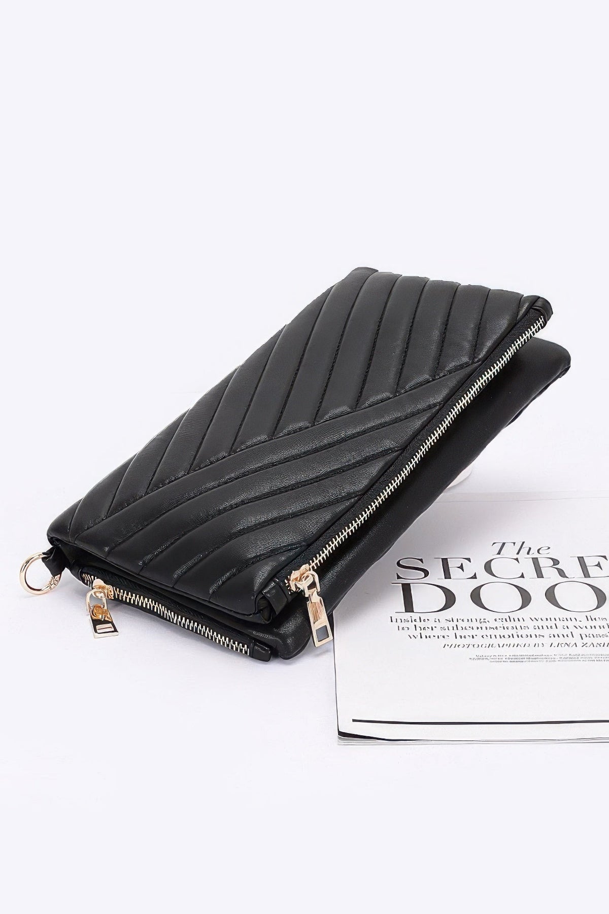 Black chevron quilted clutch with top zip, slanted profile, and chain-strap hardware