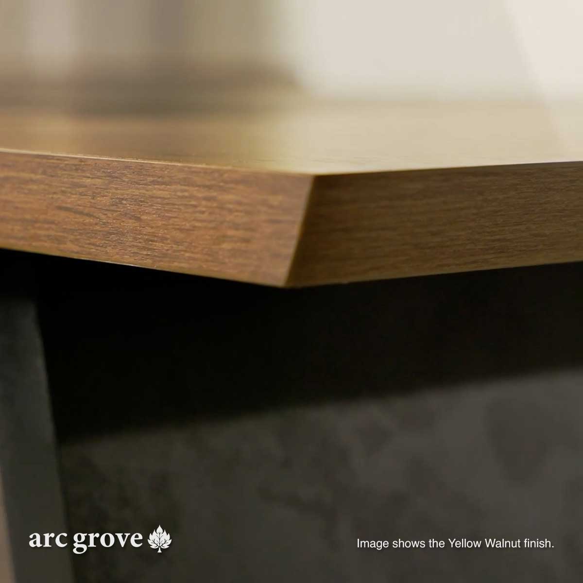 Close-up of wood-look tabletop edge over dark base panel