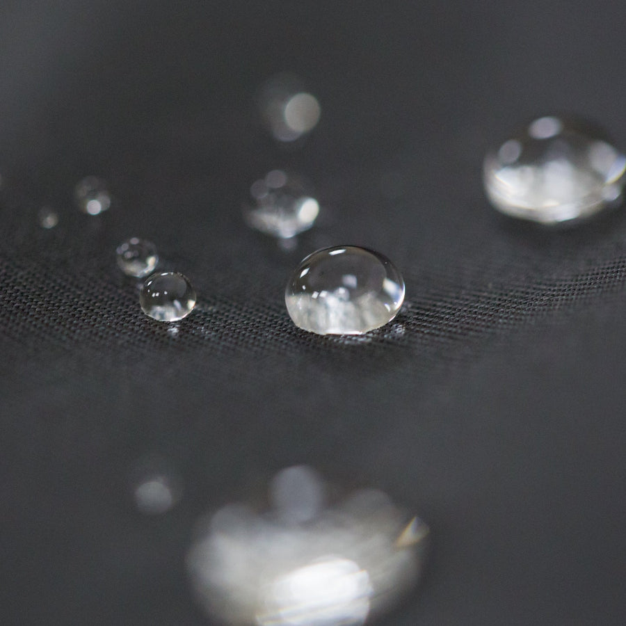 Waterproof fabric with visible water droplets beading on the surface.