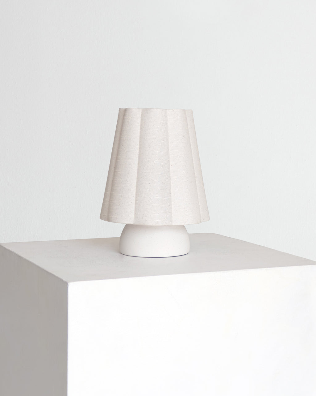 Minimal table lamp with white fabric drum shade and white pedestal base