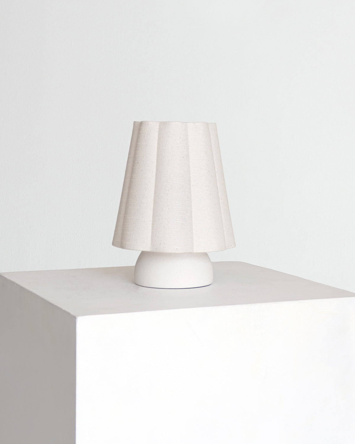 Minimal table lamp with white fabric drum shade and white pedestal base