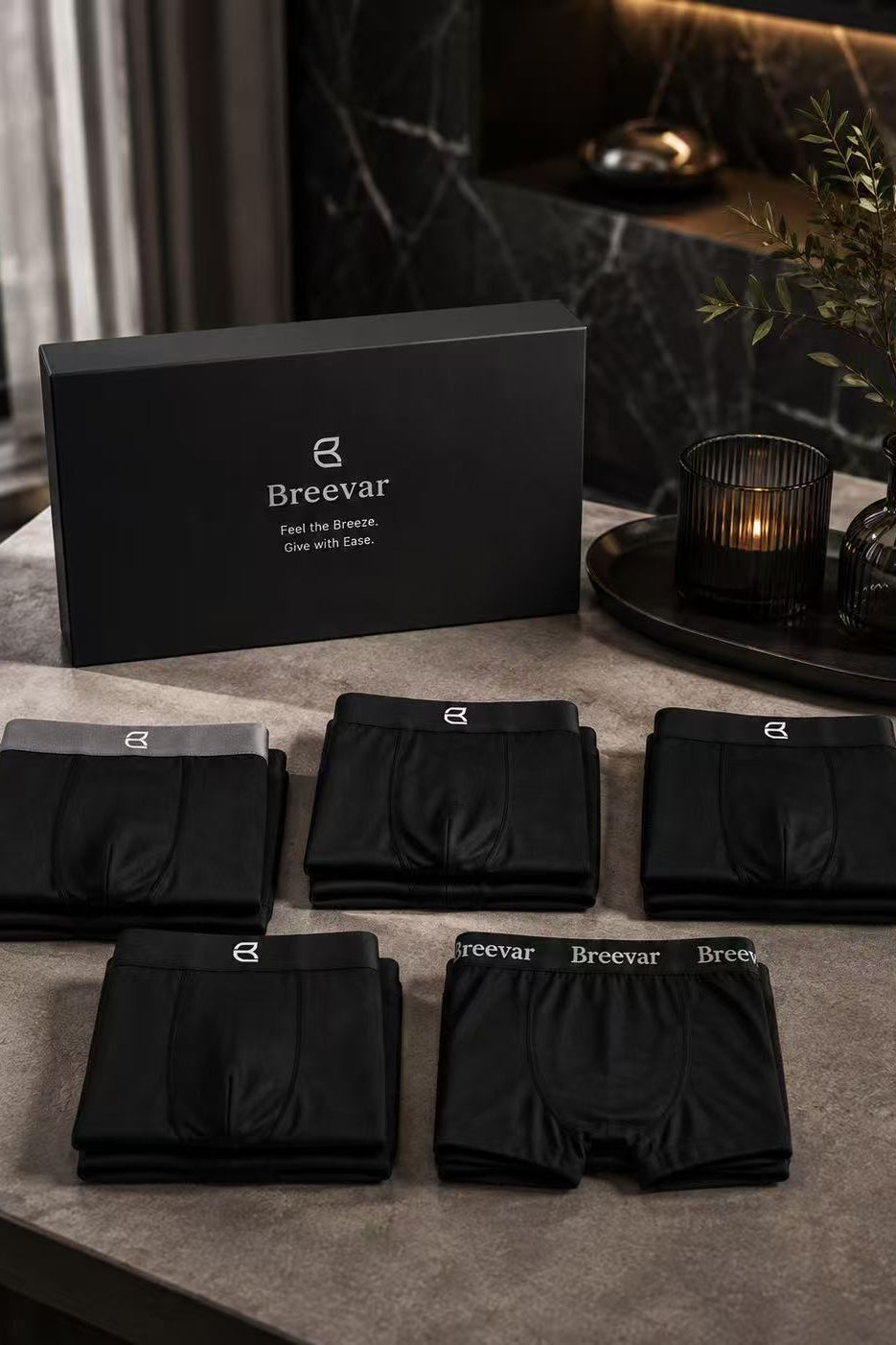 Gift box with multiple folded black boxer briefs, some pairs stacked