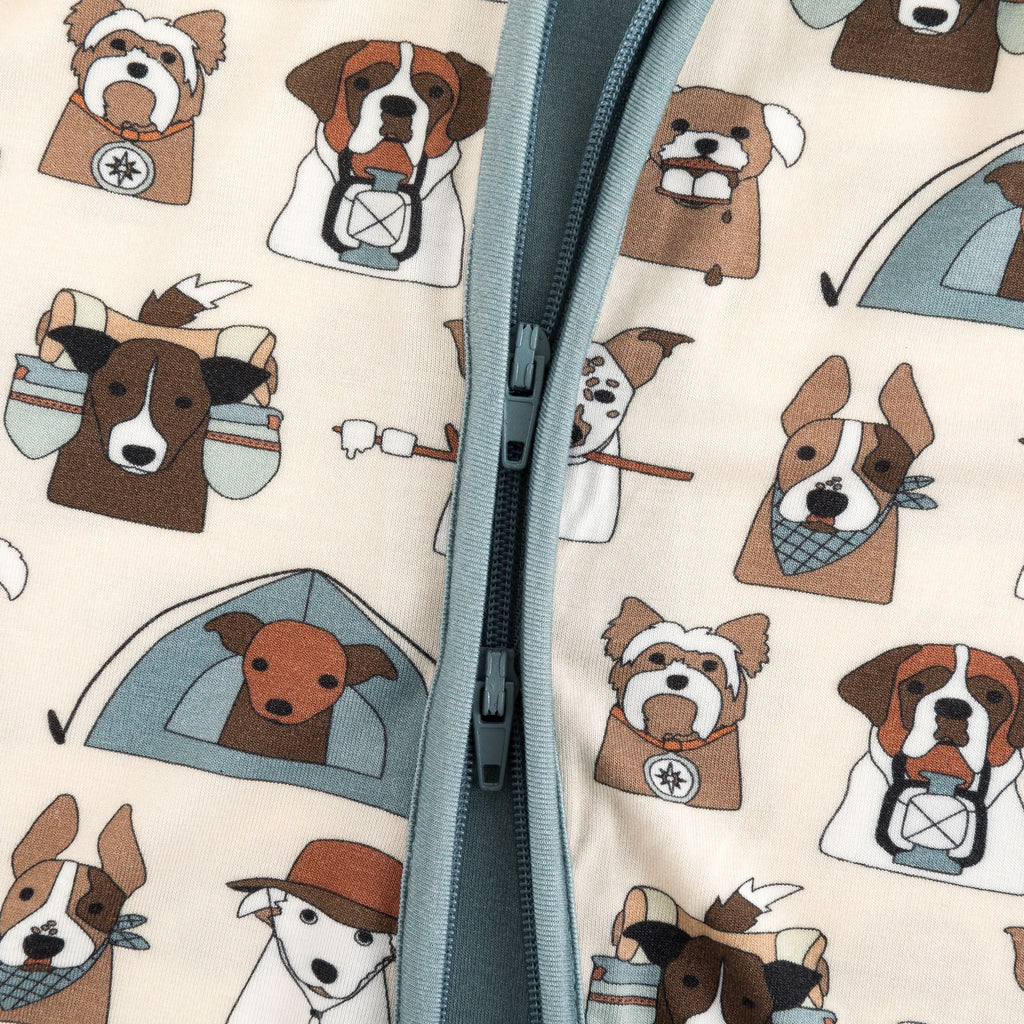 Close-up of cream dog-themed print convertible zip footie fabric with blue-gray zipper