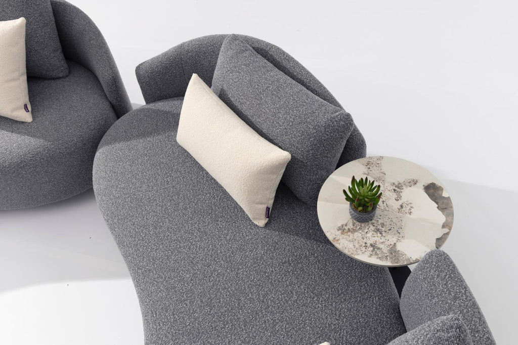 Gray outdoor armchair with light throw pillow and round side table
