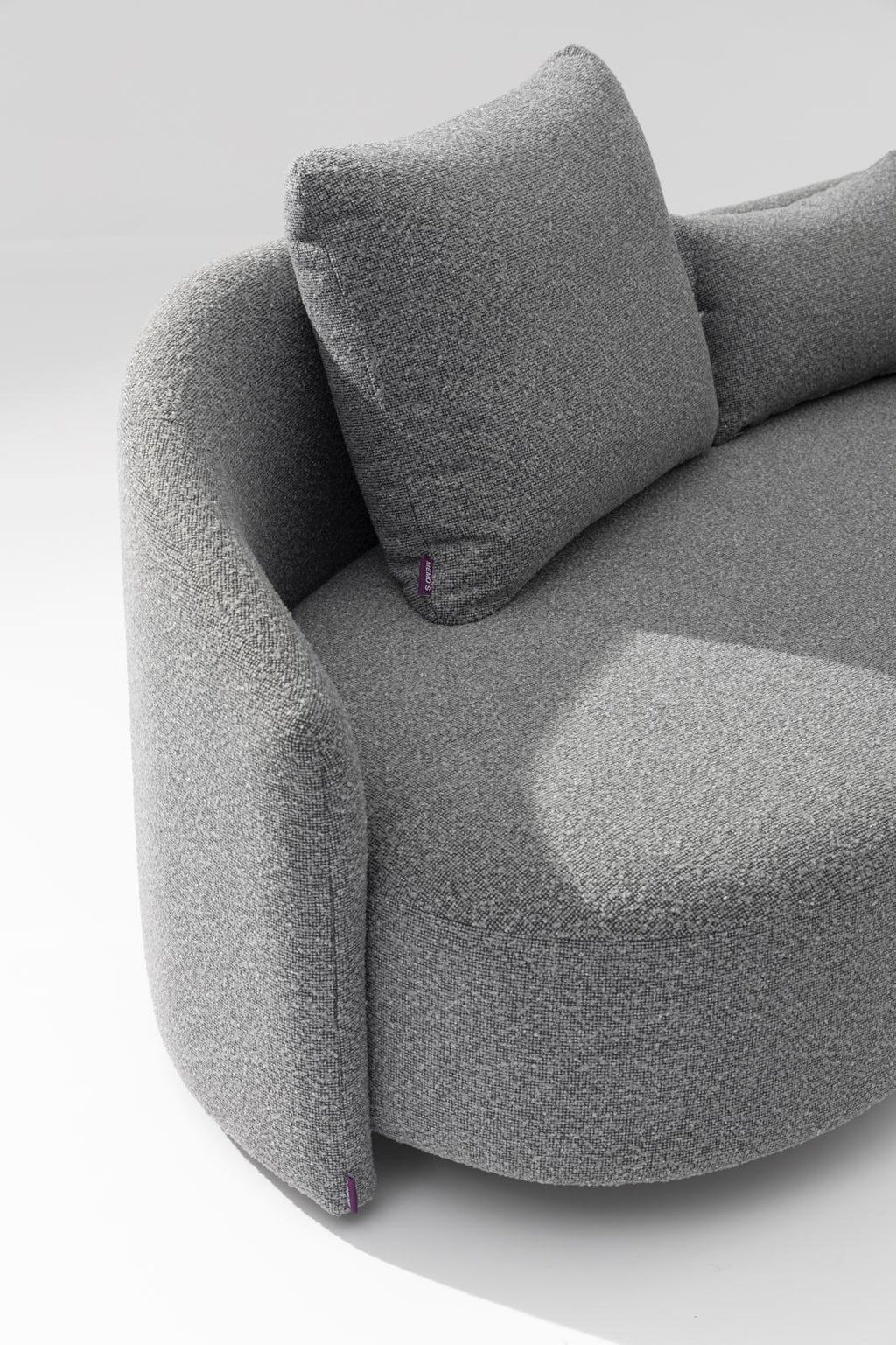 Gray outdoor lounge sofa with curved armrest and two upholstered cushions