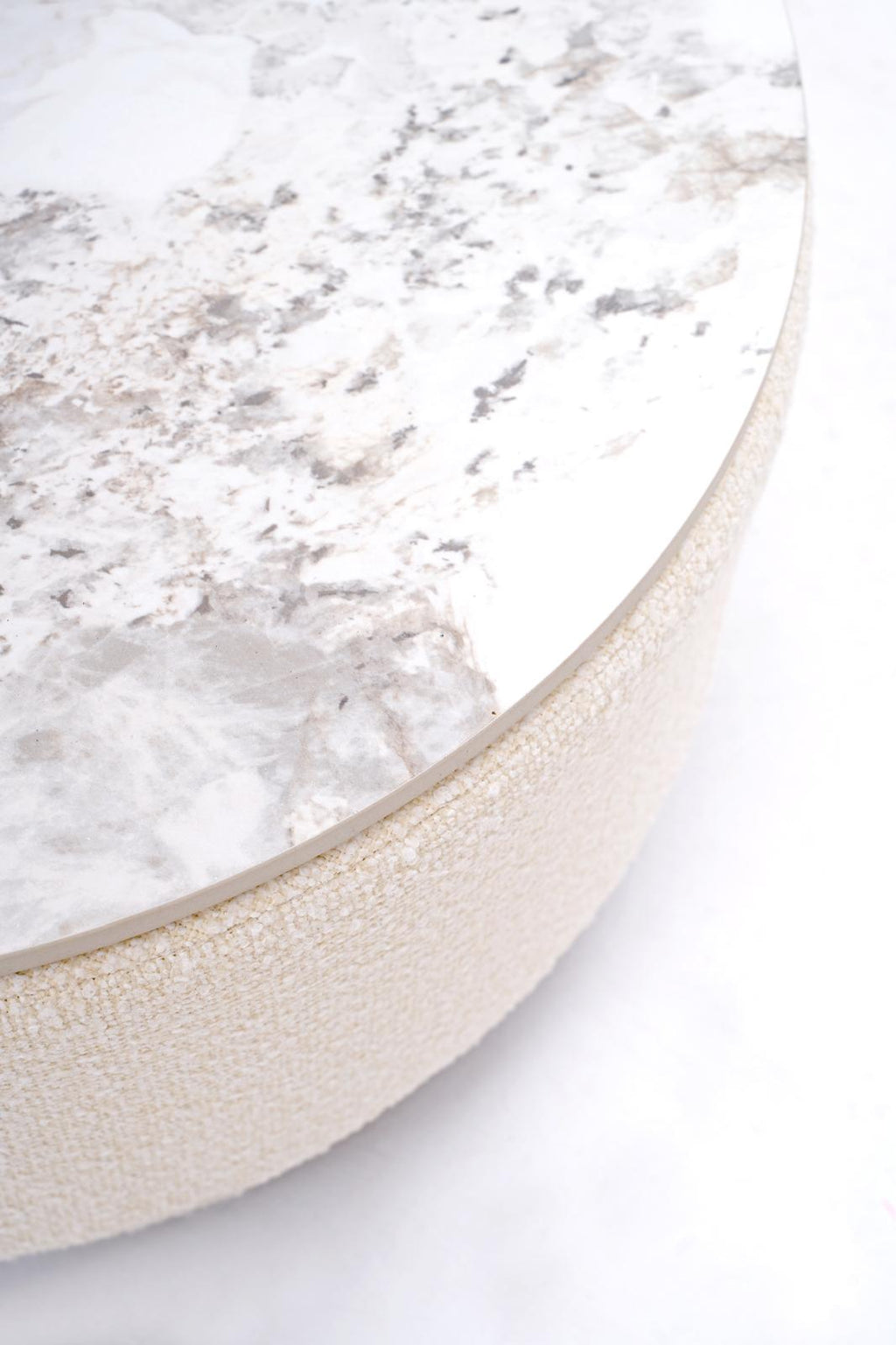 Round table edge with white marble-look surface and beige textured rim