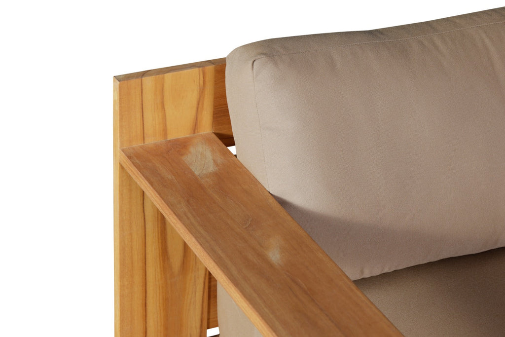 Teak armchair armrest detail with beige cushions and curved cushion edges.