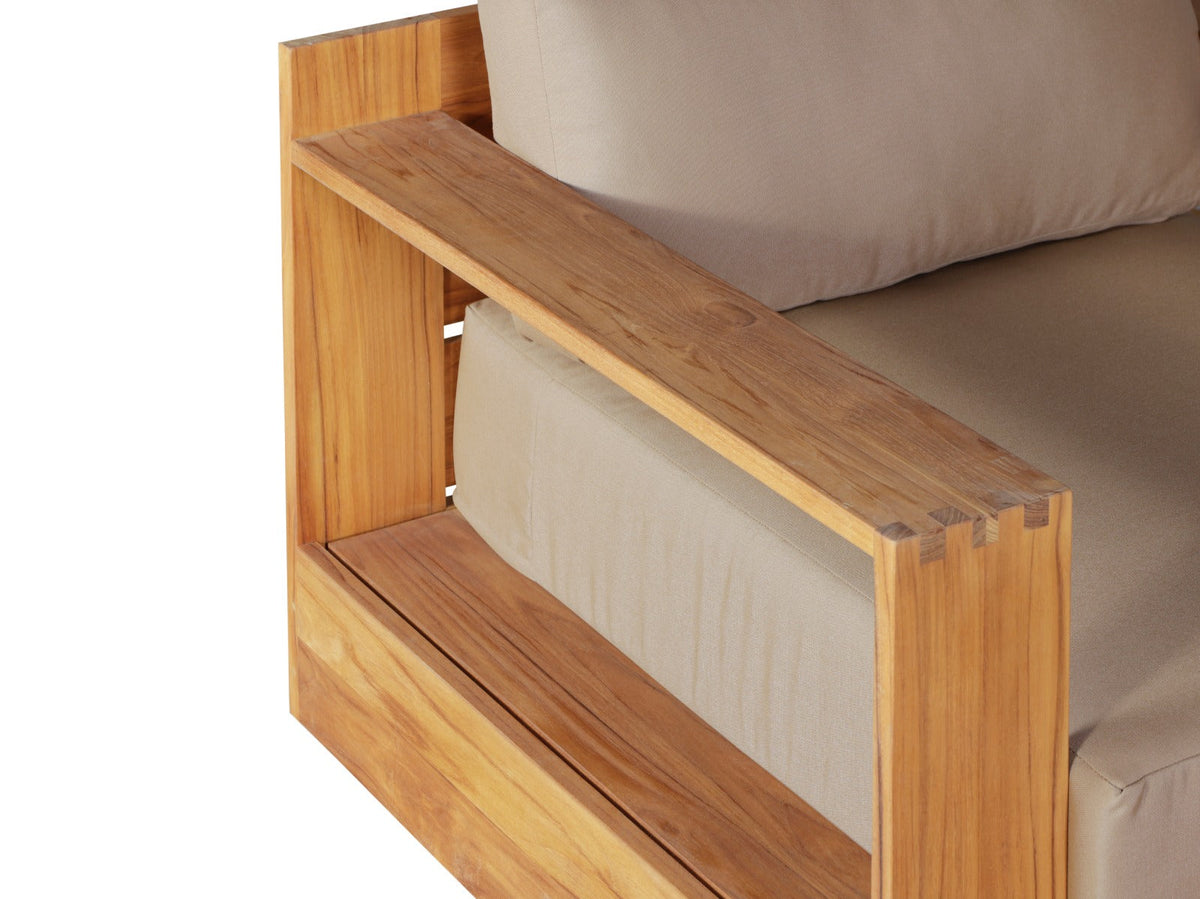 Teak outdoor chair with beige cushions and two-tier armrest support, side view