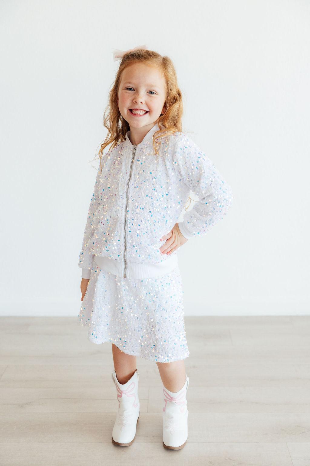 White sequined jacket with front zipper, long sleeves, and matching skirt hem