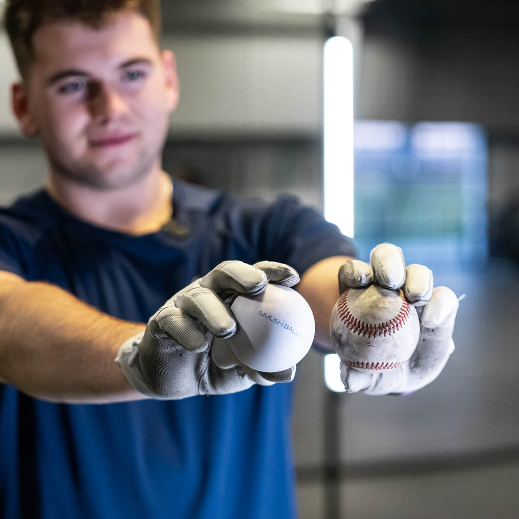 White SMUSH BALLS stress balls in gloved hands, one ball held near a baseball.