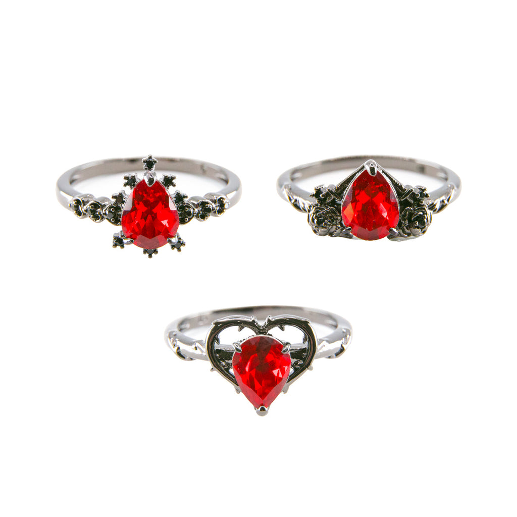 Set of three views of silver rings with red teardrop gemstones