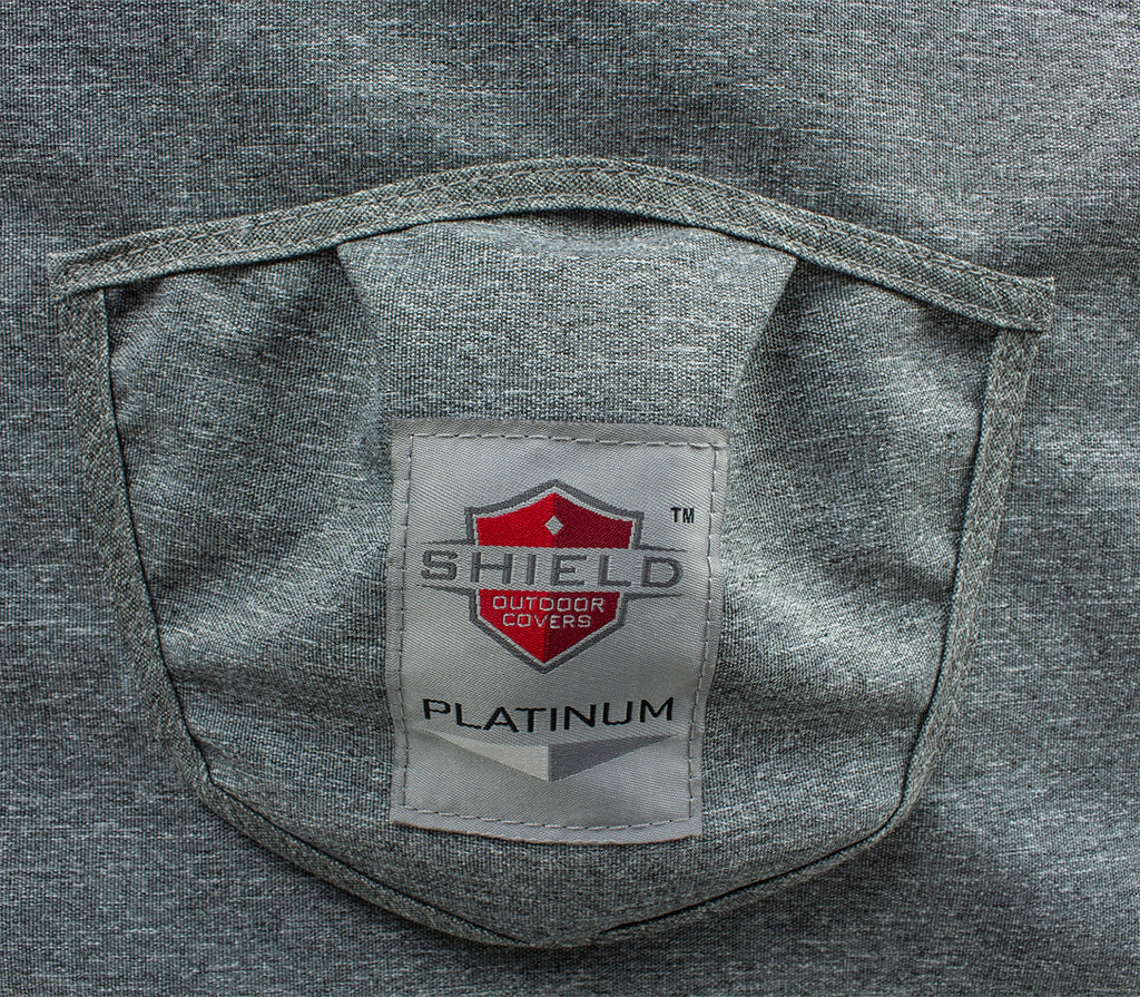 Gray loveseat cover with interior brand logo patch and stitched pocket opening