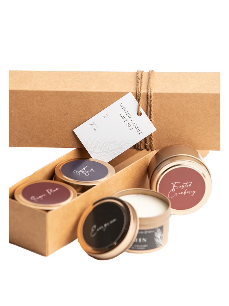 Candle gift set gift box open with four candle tins and paper label on top.