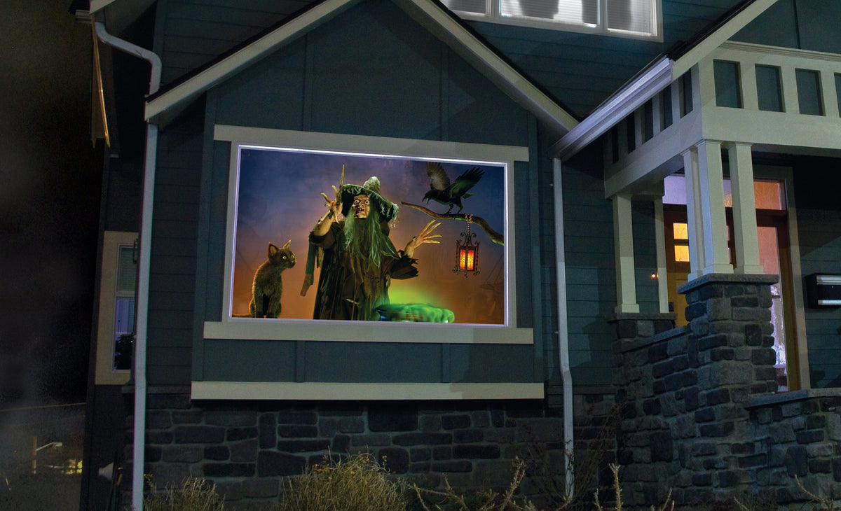 USB projector projecting green witch artwork inside a window opening