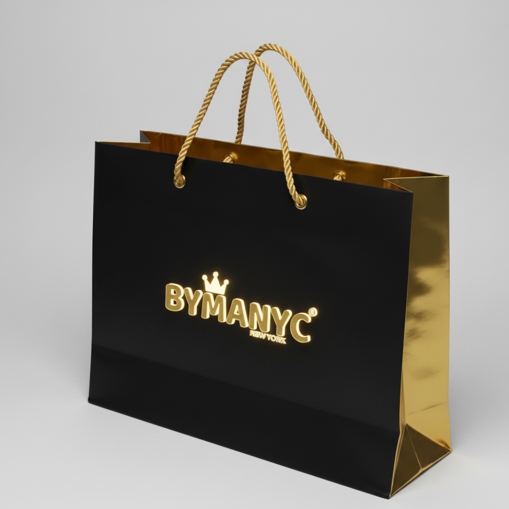 Gold and black BYMANYC shopping bag with gold rope handles and logo