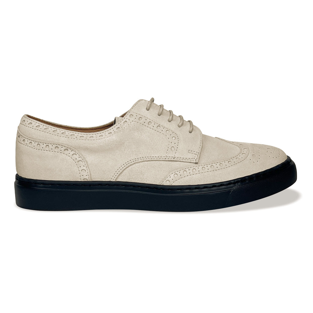 Ivory lace-up oxford shoe with perforated wingtip design and black rubber sole