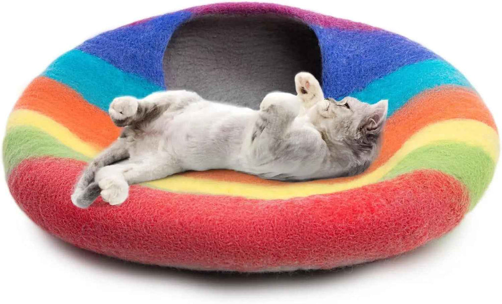 Rainbow wool cat cave bed with a cat lounging across the opening