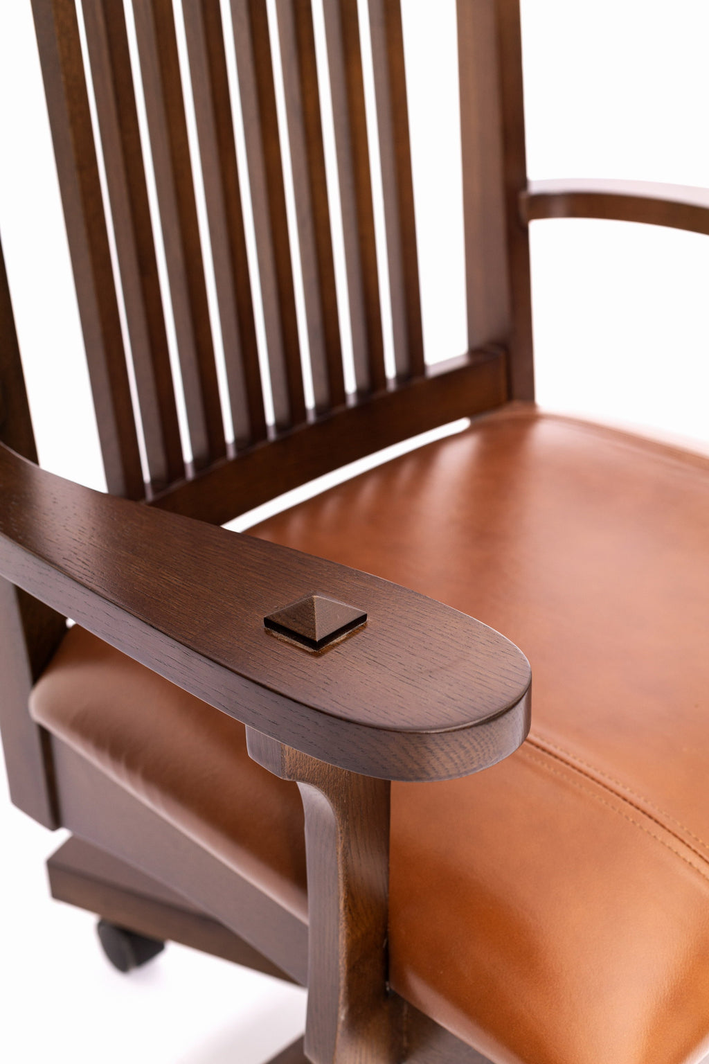Close-up of curved armrest and brown leather seat on wood slat office chair