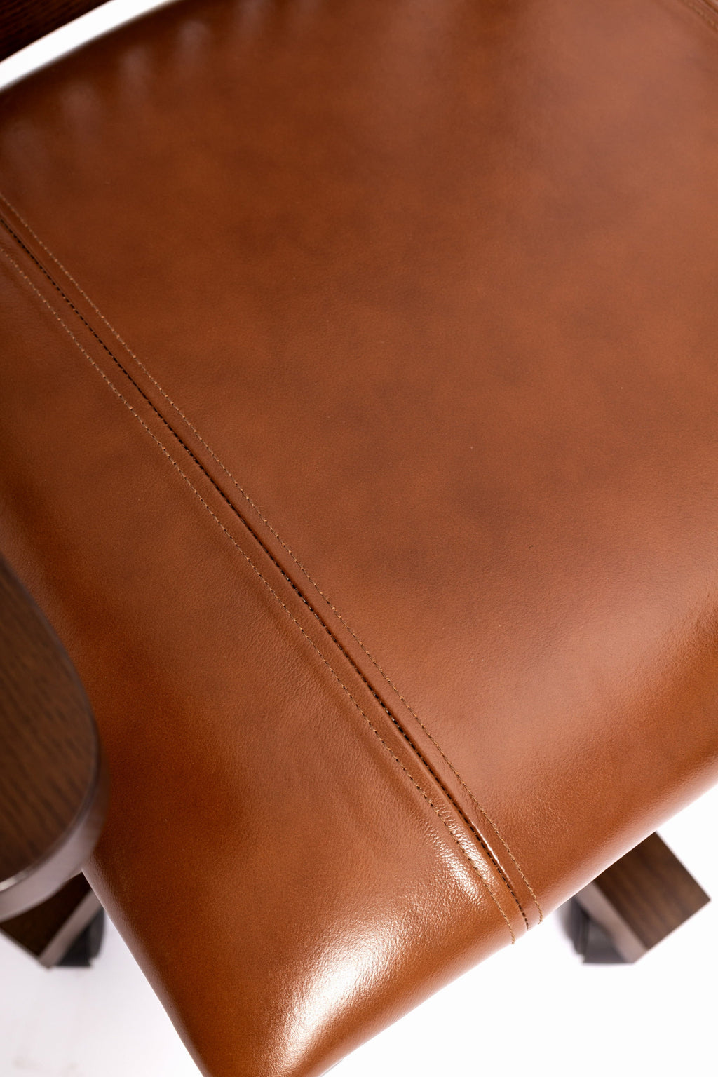 Close-up of brown leather seat cushion with neat stitched seam