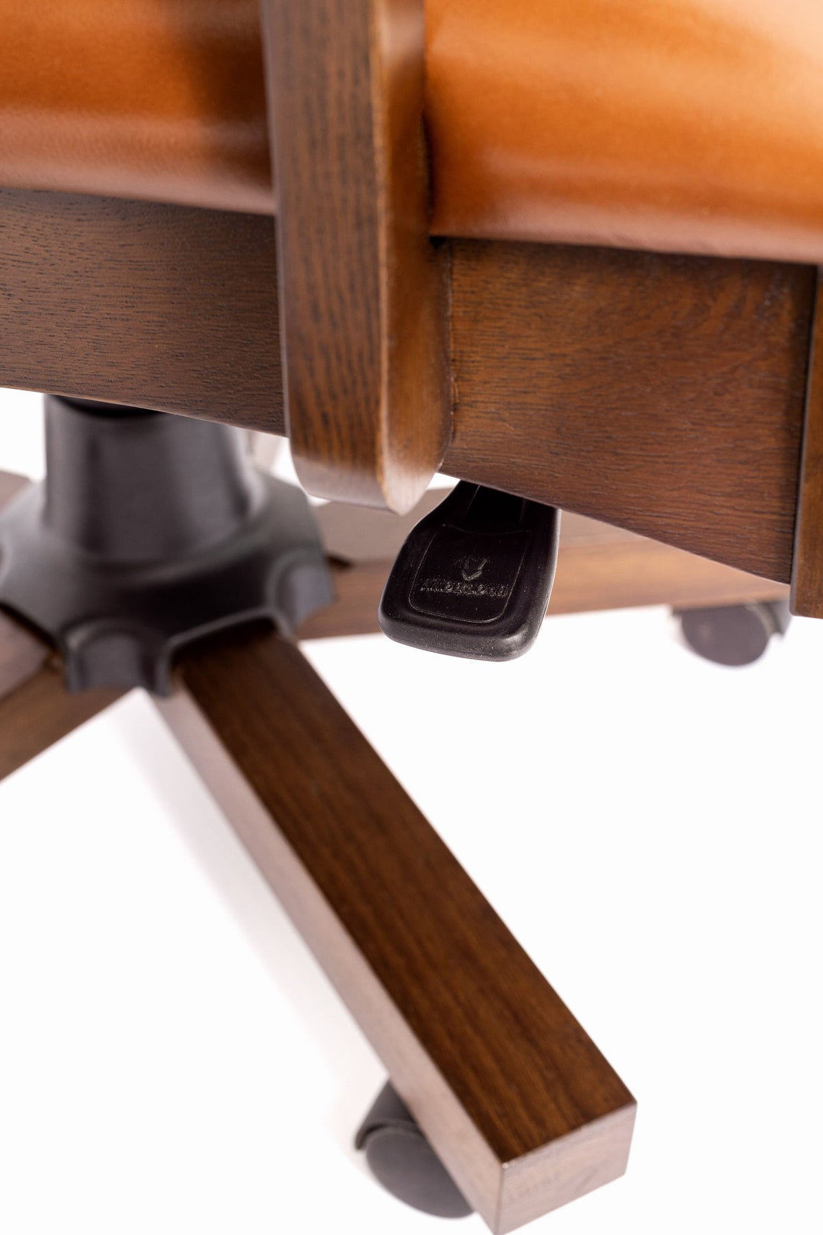 Close-up of wood leg and black swivel caster base beneath the chair