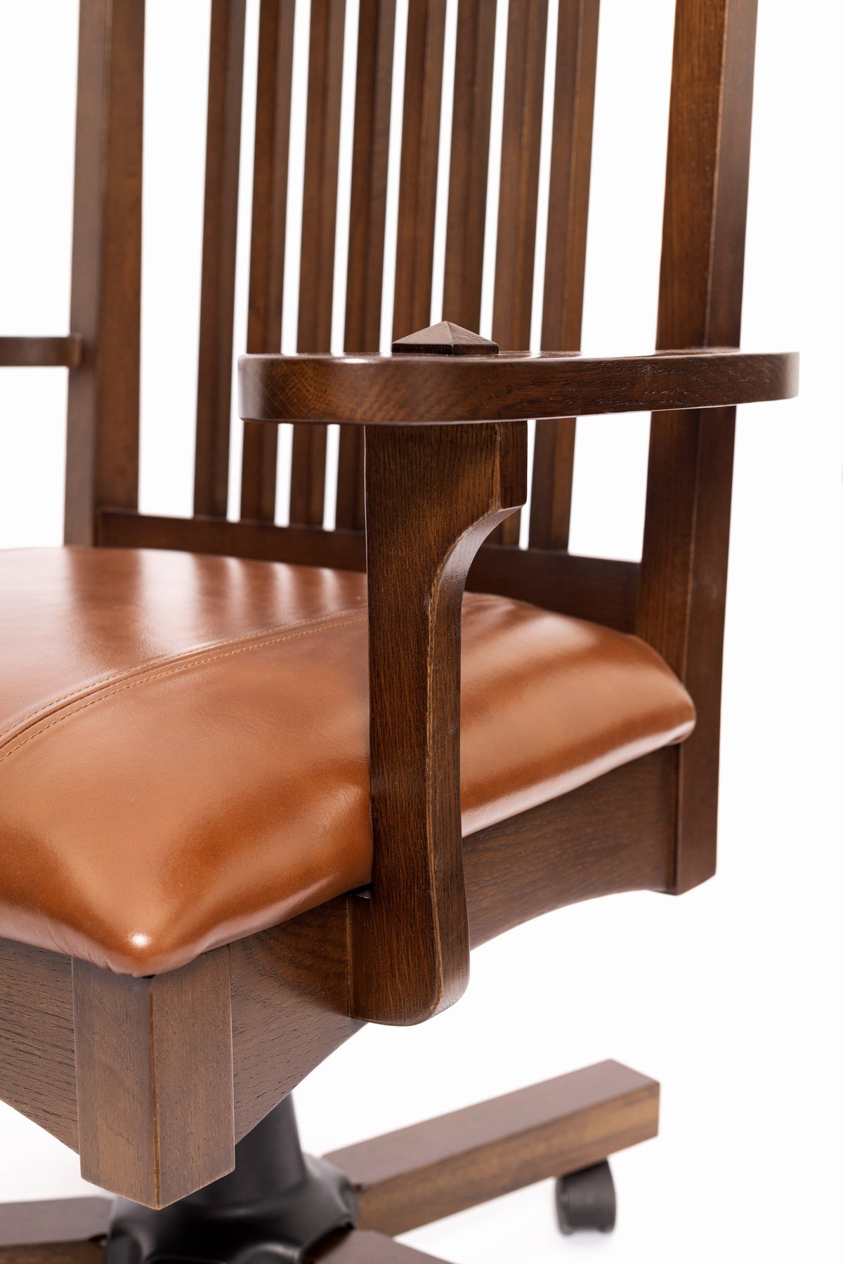 Close-up of slat back, armrest, and brown leather seat on swivel office chair
