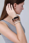 Braided hair ties set on wrist with jeweled center beads in dark, brown, and cream.