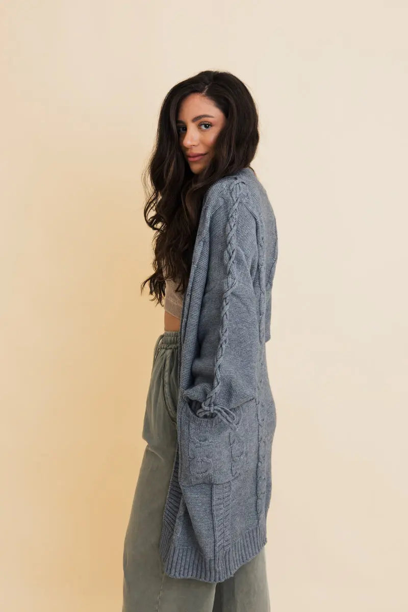 Blue cable-knit cardigan with side-tie sleeve details and ribbed cuffs, open front
