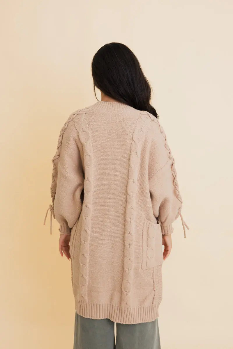 Khaki cable-knit cardigan back view with ribbed hem and tie cuffs