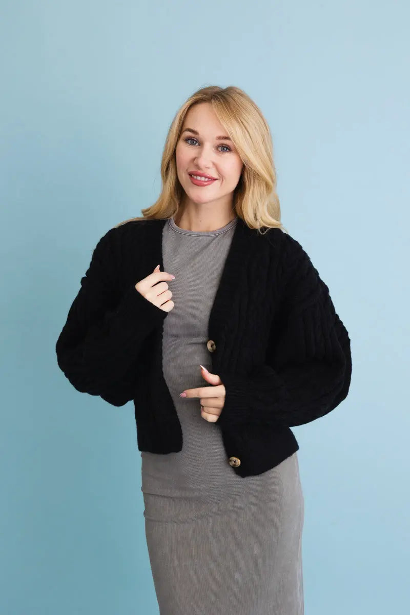 Black cropped cable-knit button-up cardigan, front view with round gold buttons