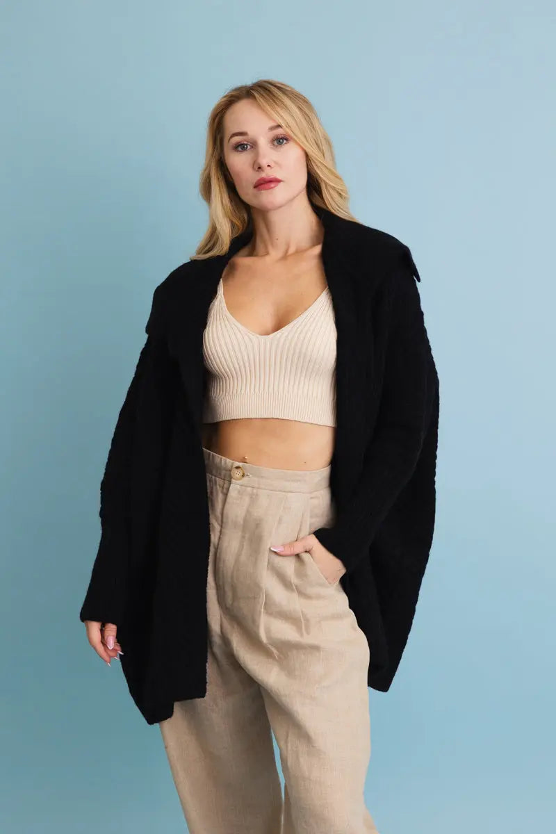 Chunky cable-knit poncho cardigan in black, oversized shawl-collar front