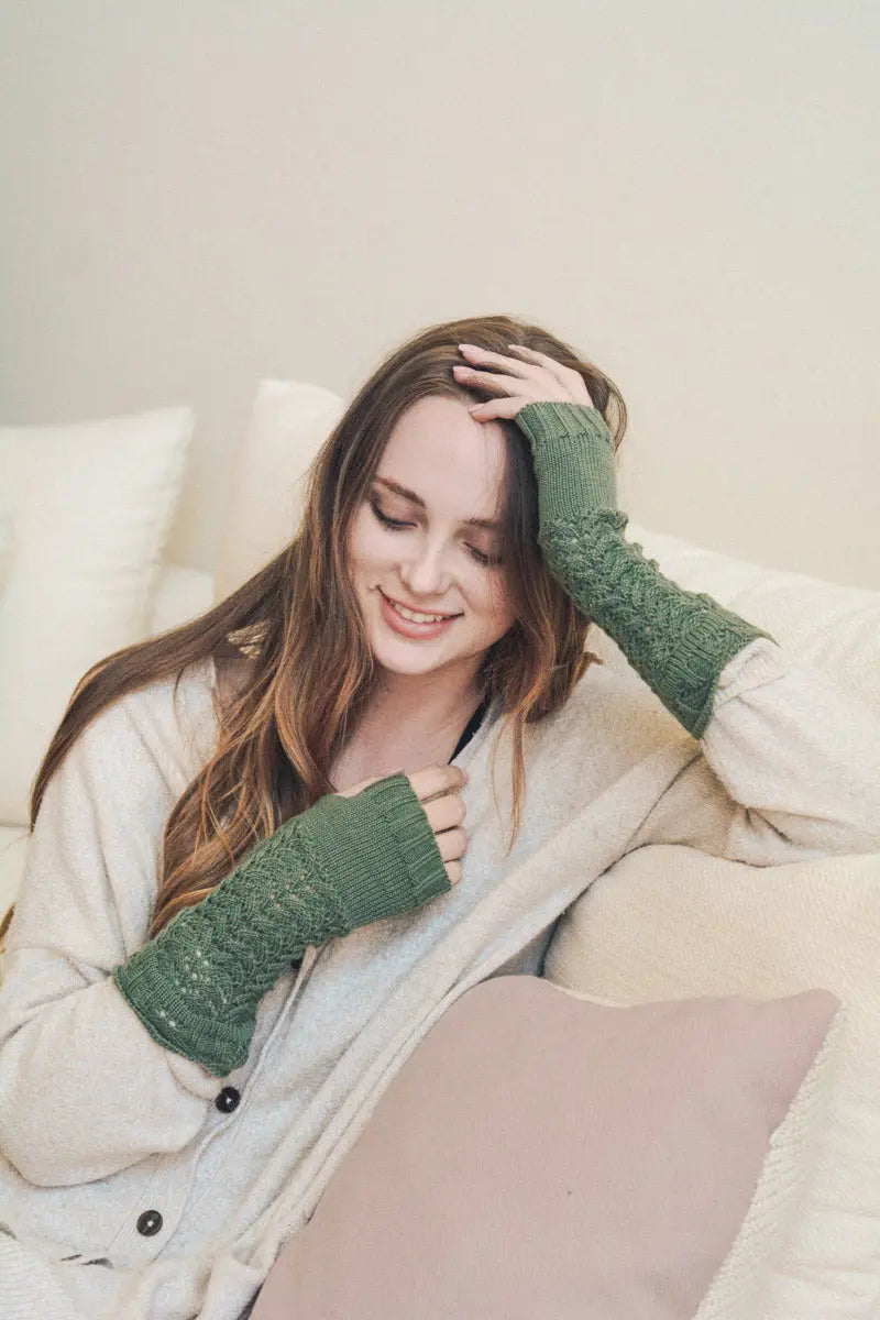Sage green knit texting-friendly arm warmers with ribbed cuffs and fingertip openings