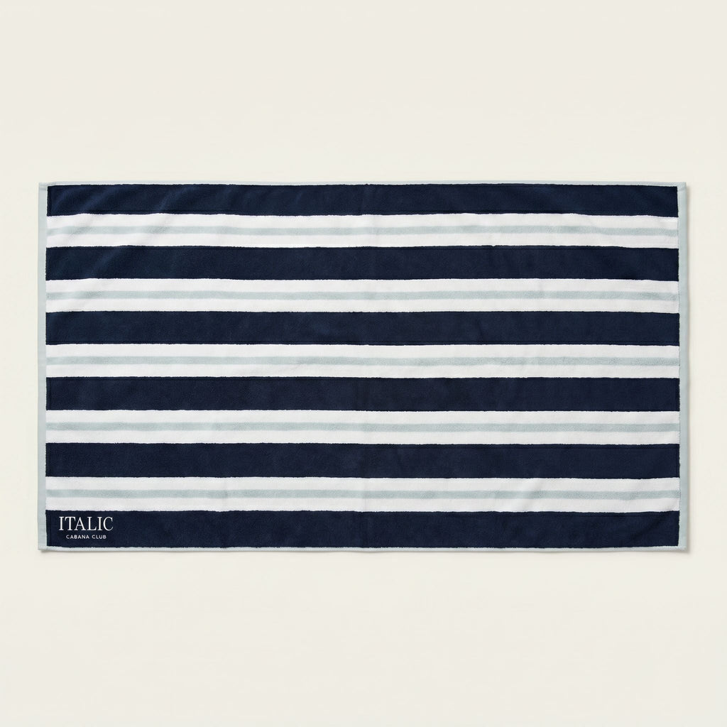 Cotton beach towel with navy and white horizontal stripes and woven “ITALIC” label