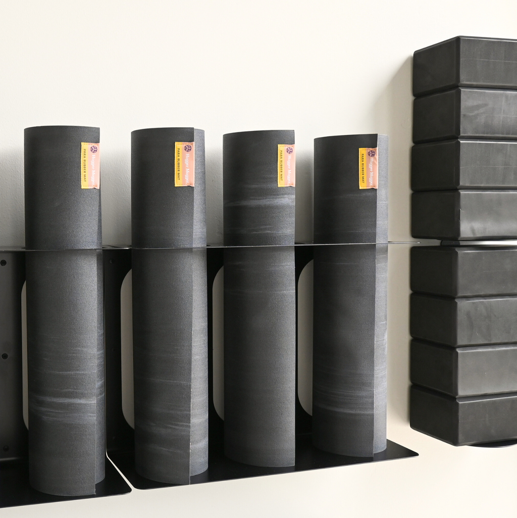 Black yoga mat rack holding multiple upright yoga mats