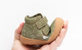 Toddler hiker boot held in hand, olive speckled fabric, sherpa lining, Velcro strap