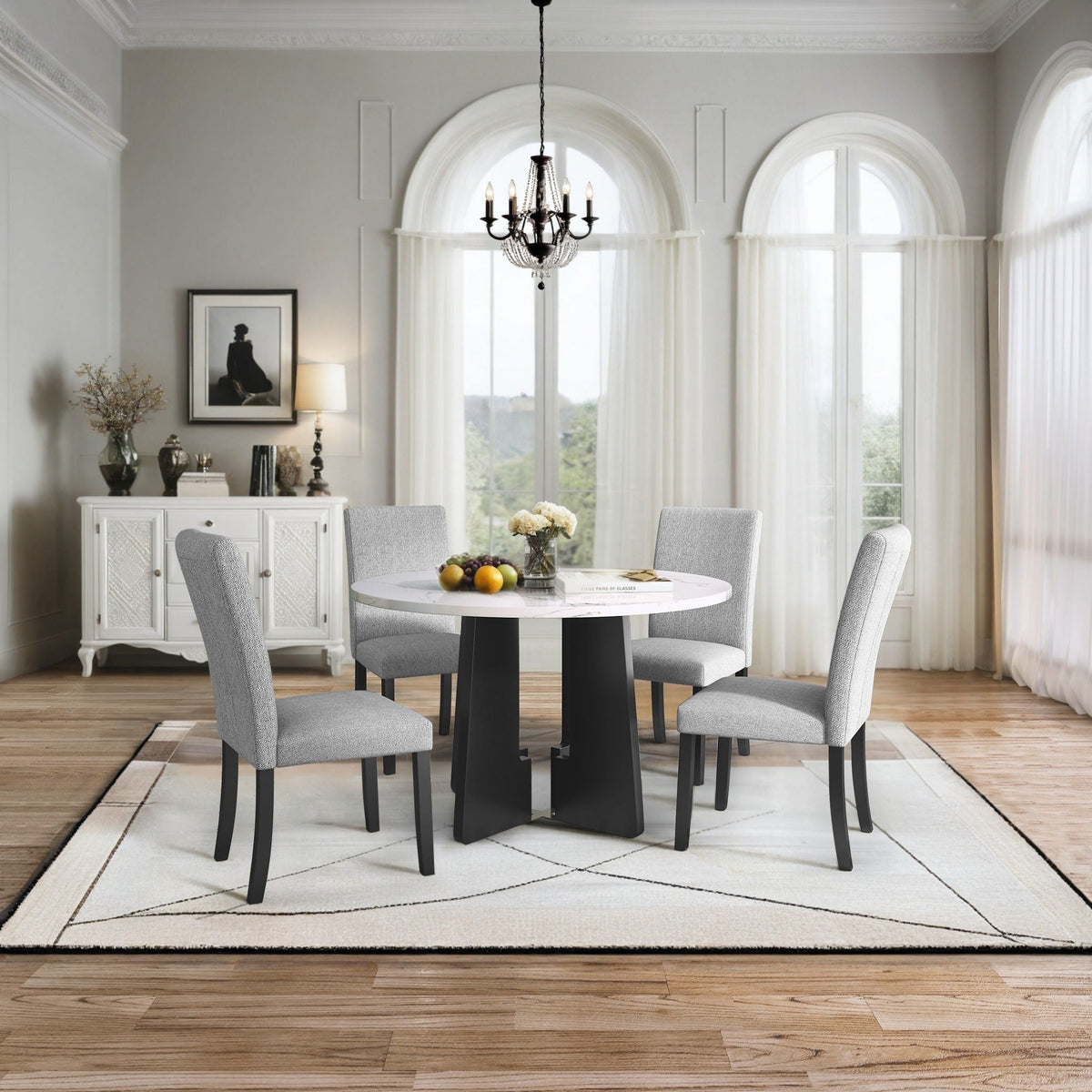White round dining table with four gray upholstered chairs in a dining set