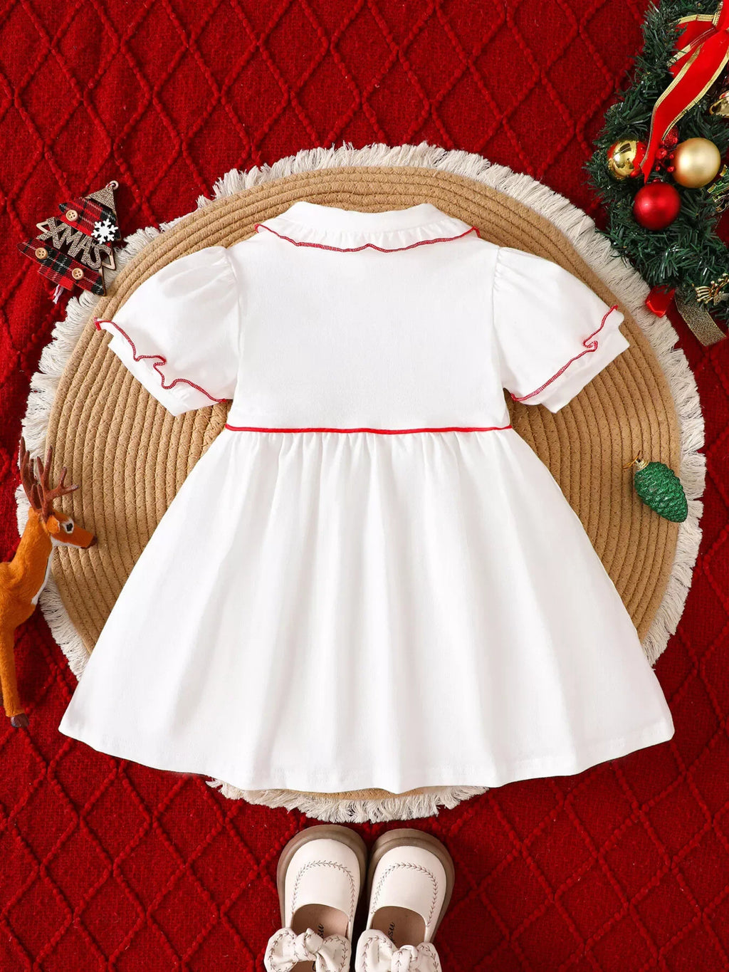 White children's Christmas dress with red piping, button front, and short sleeves